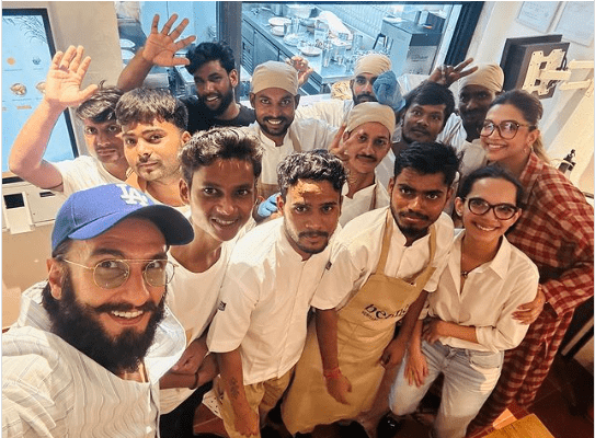 Deepika Padukone, soon to become a mother, in a new photo that has appeared online and again created a ripple in the social media. The picture shows Ranveer Singh together with the employees of the restaurant they dined.